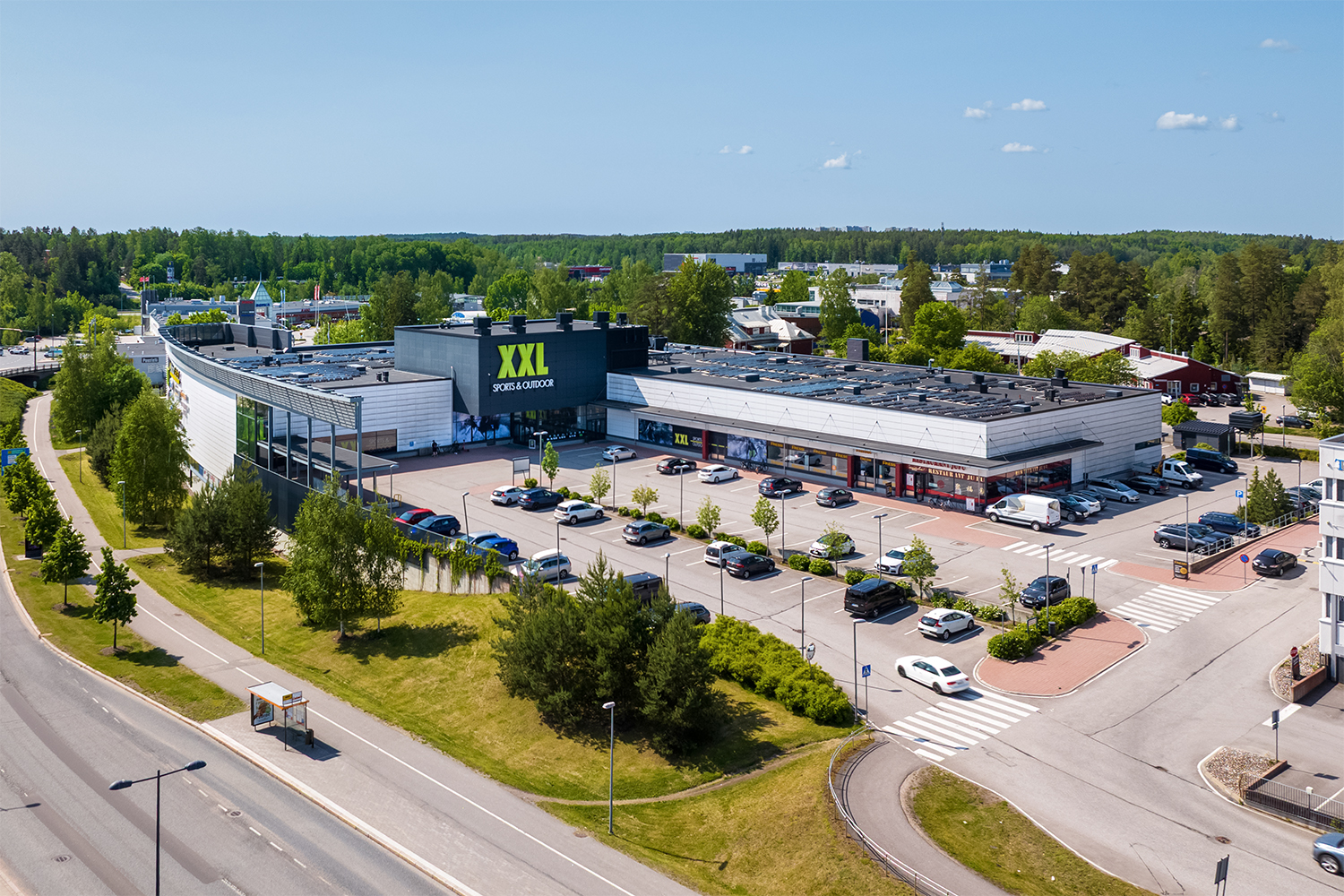 Toimitilakiinteistön ulkokuva, L-muotoinen kiinteistö, jonka julkisivulla iso XXL mainoskyltti
